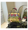 Detalle del bolso bandolera con forma de concha, textura de serpiente y cremalleras metálicas - Verde