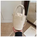 Offwhite Eimertasche aus genarbtem Leder mit Kordelzug und Umhängeriemen - Gebrochenes Weiß