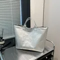 Silver metallic tote bag with wrinkled texture and white printed text on a metal cart - One Size / Silver