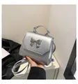 Vista detallada del bolso plateado con lazo brillante y textura de cuero PU metalizado - Talla única / Plateado
