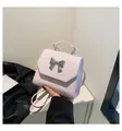 Detalle de bolso rosa claro con lazo plateado y asa superior para mujer - Talla única / Rosa