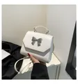 Detalle de un bolso bandolera de cuero blanco con lazo metálico plateado y un asa - Talla única / Blanco