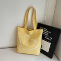 Yellow canvas tote bag with large embroidered heart and metal rivet detailing - Yellow