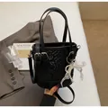 Elegante schwarze Beuteltasche mit Schlangentextur und weißer Perlen-Spitzenschleife - Mit Anhänger / Schwarz