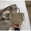 Primer plano detallado del bolso tipo cubo crema de cuero PU con ojales metálicos - Talla única / Blanco Roto