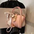 Sac seau en cuir grainé rose avec foulard imprimé en soie et boucle dorée élégante - Rose