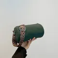 Dunkelgrüne Zylindertasche mit breitem Leopard-Schultergurt und silbernen Beschlägen - Grün