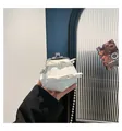Dettaglio borsa bianca in pelle martellata con chiusura metallica e fiocchi - Bianco