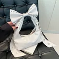 Modische perlweiße Schleifenhandtasche mit silbernen Nieten und plissierter Ledertextur - Einheitsgröße / Weiß