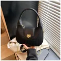 Dettaglio borsa a mezzaluna in pelle nera intrecciata con chiusura oro e catena - Taglia unica / Nero