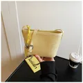 Light yellow woven bucket bag with adjustable leather strap and knot detail - With Pendant / Yellow