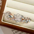 Rose gold floral spring clip with luxury rhinestones and crystal leaf detail - White