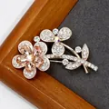 Elegant rose gold flower brooch with champagne crystals on a textured grey background - Champagne Crystal Flower