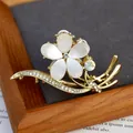 Gouden bloem haarklem met witte kattenoog bloembladen en fonkelende strass - Bloemvorm / Gevallen Bloemen
