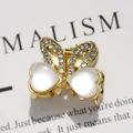 Goldene Schmetterling-Haarklammer mit herzförmigen Katzenaugensteinen und Kristallen - Katzenaugen-Hasenohr