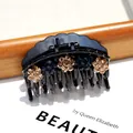 Elegant black acrylic hair claw clip with vintage champagne and navy rhinestone flowers - Arc Yellow and Blue