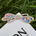 Bow-shaped hair clip with multicolor rhinestones on alloy base shown on white card - Color No. 6