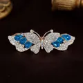 Gouden vlinder haarklem met witte kristallen en donkerblauwe accenten - Blauw