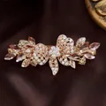 Elegant rose gold flower hair clip with champagne crystals on brown satin background - Bow Yellow