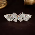 Gouden vlinder haarclip met witte strass steentjes en een iriserende opaal - Wit