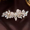 Elegant rose gold flower hair clip with sparkling crystals on dark brown silk fabric - White Bow