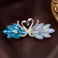 Luxurious swan heart hair clip with blue and white crystals on a golden base - Crystal Swan Blue