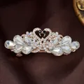 Rose gold swan hair clip with white crystals on a luxurious brown satin background - Glass Swan White