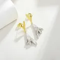 Detail van 14K vergulde oorbellen met onregelmatige golvende metalen kunstzinnige texturen - Goud Zilver Tweekleurige Lava Textuur Stijl
