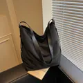 Bolso tote de lona negra con correas anchas de cuero y hebillas metálicas - Negro
