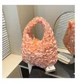 Close-up of light pink satin handbag featuring elegant pleated ruffles and textured finish - One Size / Pink