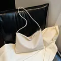 Minimalist creamy white dumpling bag with lychee texture and smooth metal zipper closure - With Elephant Pendant / Off White