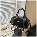 Detalle del bolso Boston en charol negro con herrajes dorados vintage y textura arrugada - Talla única / Negro