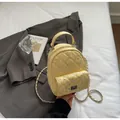 Close-up of quilted yellow mini backpack with rhinestone details and metal chain straps - Yellow