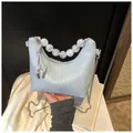 Detail of light blue croc-embossed hobo bag with unique white marble bead handle strap - Blue Crocodile Pattern