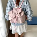 Mochila rosa claro de nailon con cordón usada por modelo en ambiente casero - Rosa