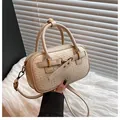 Detailed close-up of woven cream leather texture and gold hardware on the bowling bag - One Size / Beige