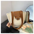 Detail der cremefarbenen Strohtasche mit brauner Lederklappe und Schultergurt - Einheitsgröße / Gebrochenes Weiß