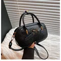 Close-up of black woven texture bowling bag with gold buckles and detachable strap - One Size / Black