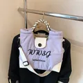 Lila-weiße Nylon-Tragetasche mit Stickerei und kariertem Griff am Kleiderbügel - Lila