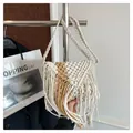 Detail van bohemien rieten tas met geweven katoenen kwastjes en een gevlochten schouderband - Wit