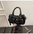 Details einer schwarzen glänzenden Ledertasche mit zwei Taschen und silbernen Beschlägen - Einheitsgröße / Schwarz
