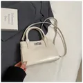 Detailansicht der cremeweißen Lederhandtasche mit Silberverschluss und feinen Nähten - Ohne Anhänger / Gebrochenes Weiß