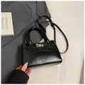 Detailansicht einer schwarzen Lackleder-Handtasche mit silbernem Drehverschluss und Griffen - Ohne Anhänger / Schwarz