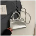 Makro-Detail der silbernen Metallic-Oberfläche und Drehverschluss der Mini-Handtasche - Ohne Anhänger / Silber