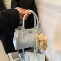 Metallic silver minimalist shoulder bag with a cute bear charm and twist-lock detail - With Charm / Silver (With Charm)