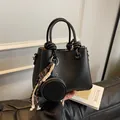 Minimalist black lychee leather bucket bag with knotted handles and matching coin pouch - No Pendant / Black