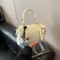 Borsa a mano minimalista in pelle bianca con goffratura MUHETI e charm a cavallo blu - senza ciondolo / Bianco