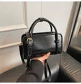 Détail d'un sac à main en cuir verni noir avec lettres embossées et boucles dorées - Sans pendentif / Noir