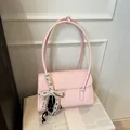 Pink minimalist PU shoulder bag with lace bow charm placed on an open book - No Pendant / Pink