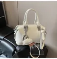 White faux leather Boston handbag featuring a heart-shaped charm and adjustable shoulder strap - With Heart Charm / White